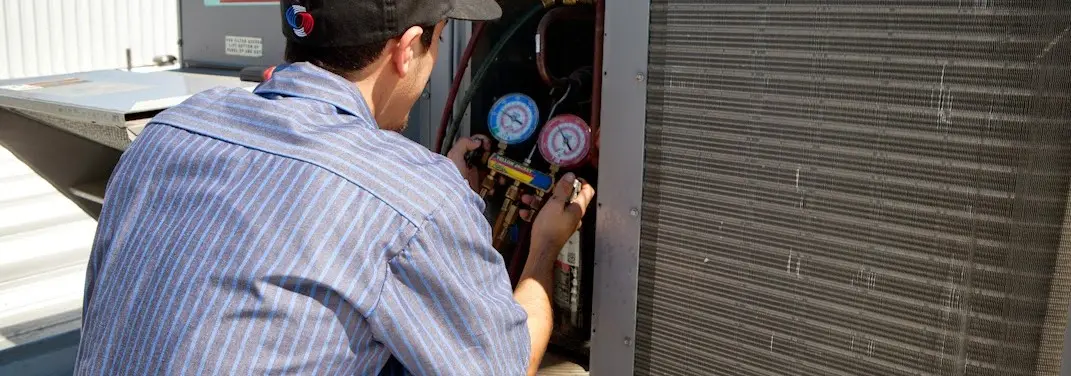 HVAC technician servicing a condenser unit in Yorktown
